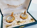 pair of gold plated spoons and spoon rest in a blue box