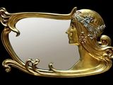 un miroir doré dans lequel se reflète la tête d'une femme