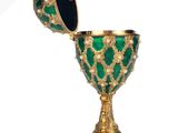 a close up of a green and gold goblet on a white background