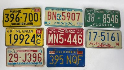several different license plates are arranged in a row on a table