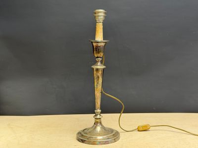 an antique silver plated table lamp with a wooden stick on it