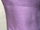 the back of a purple chair with a black and white cat sitting on top of it