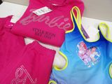 several children ' s clothing items are displayed on a table
