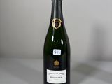 une bouteille de champagne posée sur une table à côté d'une bouteille de vin