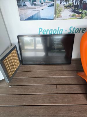 une chaise orange posée à côté d'un téléviseur, sur un parquet