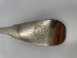 a silver spoon with a wooden handle on a white surface