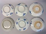 six blue and white plates with blue flowers on them on a white surface
