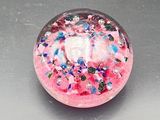 a pink donut with sprinkles on it on a table