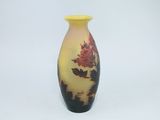 un vase jaune orné de fleurs rouges sur fond blanc