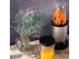 a blender that is sitting on a table next to a glass of orange juice