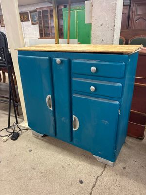 a blue cabinet with two doors and a wooden top