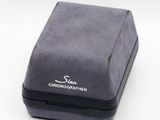 a small black box with a silver logo on it