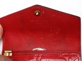 a person holding a red wallet with a gold ring