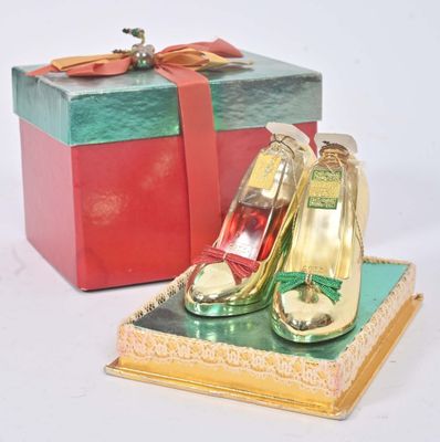 une petite boîte sur laquelle est posée une paire de chaussures dorées