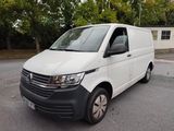 La camionnette blanche est garée sur le parking devant la maison.