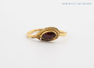 a close up of a gold ring with a red stone in it