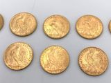 un groupe de pièces d'or posées sur une surface blanche