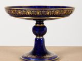 a close up of a blue and gold plate on a table