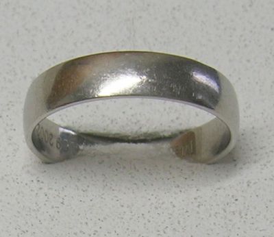 une bague en argent posée sur une table, sur fond blanc