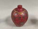 a small red vase sitting on a table next to a smaller one