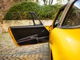a yellow car with its door open on a cobblestone street