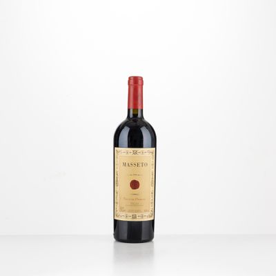 a bottle of red wine sitting on top of a white table
