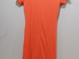 an orange dress hanging on a hanger against a wall