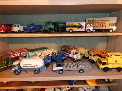 many toy trucks that are on a shelf in the room
