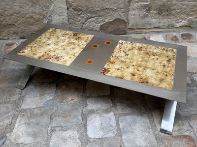 une table en métal sur laquelle se trouvent deux parts de pizza