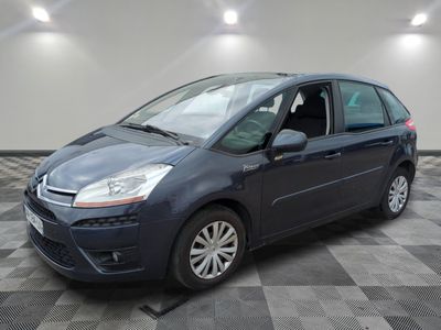 Une Citroën grise est garée sur un sol carrelé à damier.