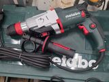 a corded drill sitting on top of a green box