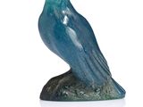 statue of a blue bird sitting on a rock on a white surface