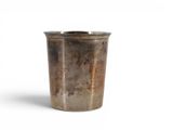 a metal cup that is sitting on a white surface