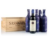 trois bouteilles de vin devant une caisse en bois contenant du vin