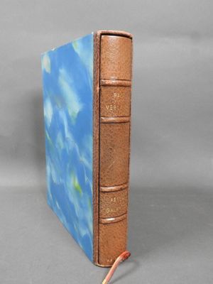 a brown book with a blue cover on a gray surface