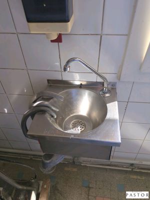 a sink in a public restroom with a hand dryer
