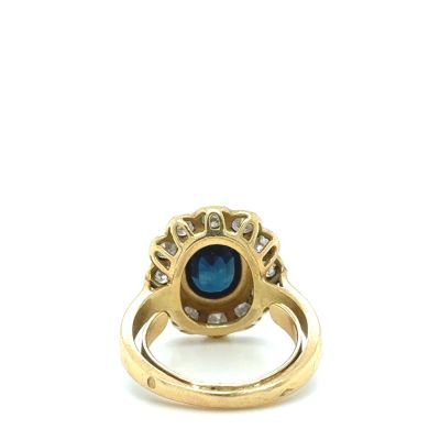 an image of a gold ring with a blue stone surrounded by diamonds