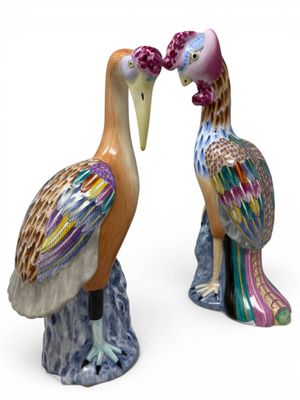 two figurines of birds that are standing next to each other