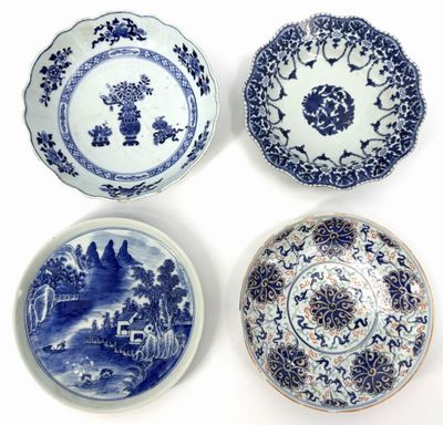 four blue and white plates with designs on them on a white surface