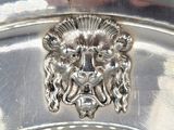 a close up of a silver plate with a lion head on it