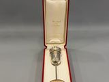 an image of a silver spoon in a red box on a gray surface