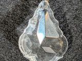 a clear crystal pendant on a black surface