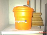 a large orange bucket sitting on top of a refrigerator