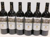 six bottles of wine are lined up in a row on a table