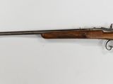 a rifle mounted on a wall in a room with a white wall