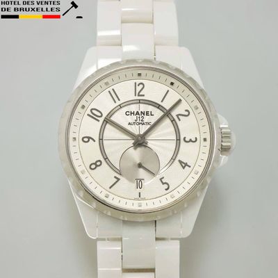 une montre blanche avec un cadran blanc posée sur une table