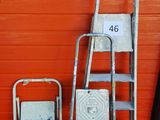 trois échelles et une chaise devant un mur orange