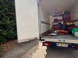 boxes in the back of a moving truck on a dirt road