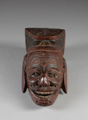 gros plan d'un masque en bois sur une surface blanche