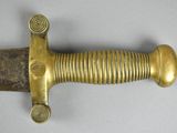 a close up of a sword on a table with a white background